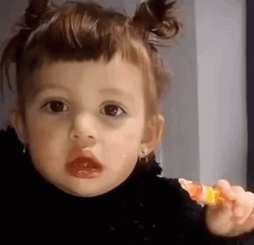 Little Girl Holding Lollipop Making Face