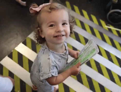 Little Girl Holding Passport on Striped Floor