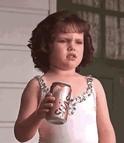 Little Girl Holding Soda Can Making Face