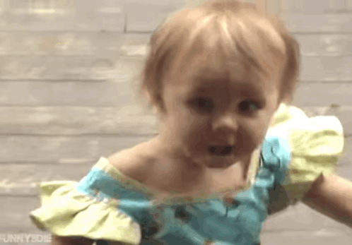 Little Girl In Blue And Yellow Dress Making A Face GIF