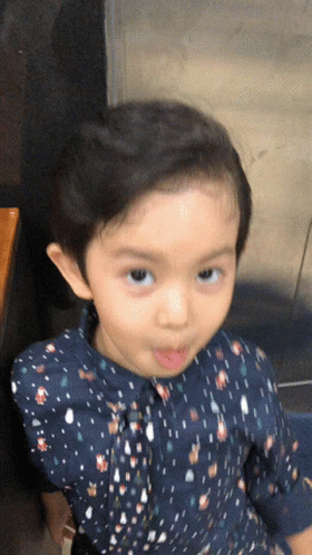 Little Girl in Blue Polka Dot Shirt Making Face