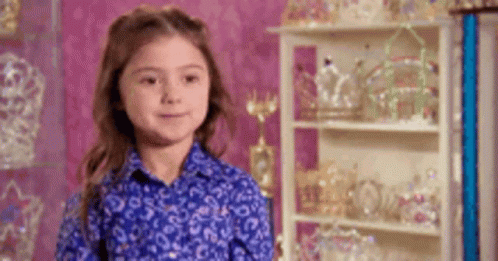Little Girl in Blue Shirt with Crowns and Tiaras