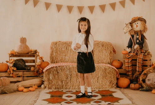 Little Girl in Front of Hay Bale