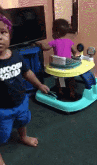 Little Girl in Moon Squad Shirt Next to Baby Walker