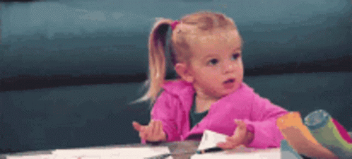 Little Girl In Pink Jacket At Table GIF