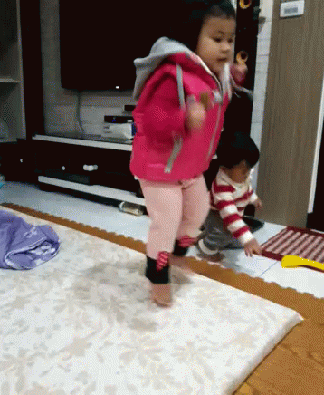 Little Girl in Pink Jacket Jumping