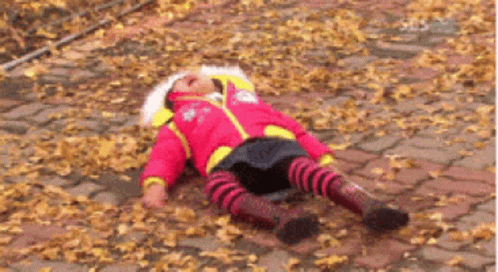 Little Girl in Red Jacket Laying on Ground