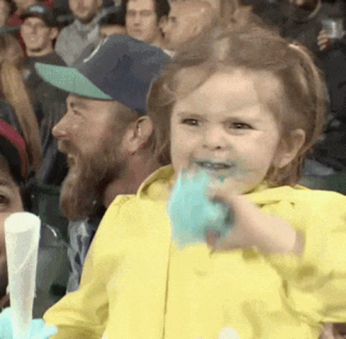 Little Girl in Yellow Jacket Eating Cotton Candy