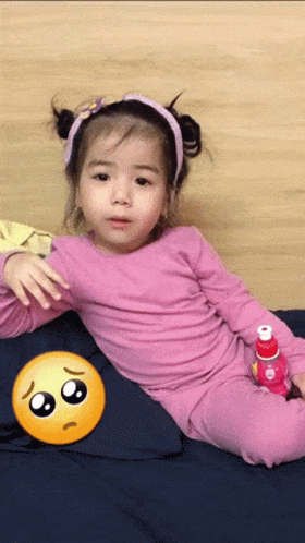 Little Girl Laying on Bed With Sad Face