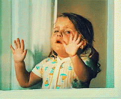 Little Girl Looking Out Window With Hands on Glass