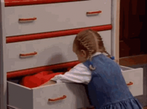 Little Girl Reaching Into Dresser Drawer