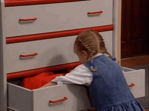 Little Girl Reaching Into Dresser Drawer