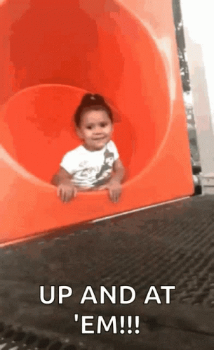 Little Girl Riding Down Orange Slide Saying Up and At Em
