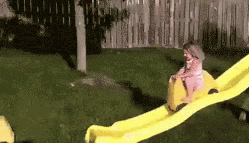 Little Girl Riding Yellow Slide
