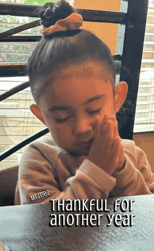 Little Girl Sitting at Table Thankful for Another Year
