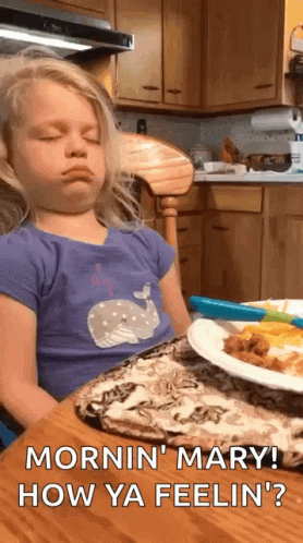Little Girl Sitting at Table with Food