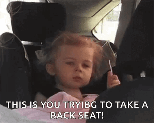 Little Girl Sitting in Car Seat Holding Lollipop