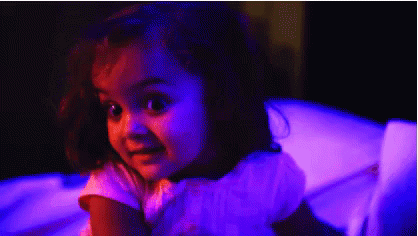 Little Girl Sitting in Chair With Purple Lights