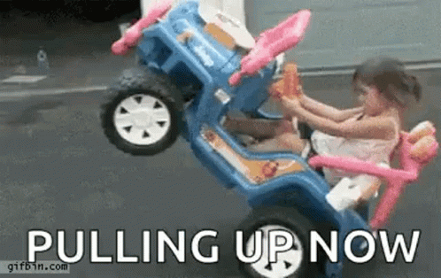 Little Girl Sitting in Toy Car Pulling Up Now
