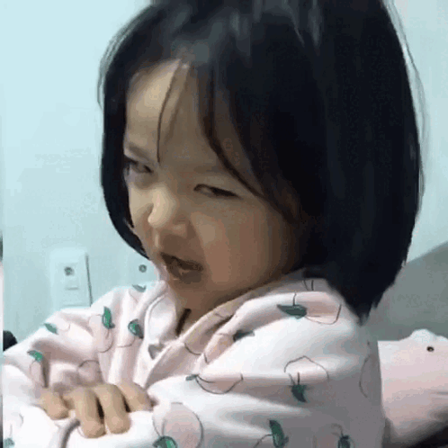 Little Girl Sitting on Bed Making Funny Face
