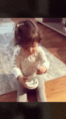 Little Girl Sitting on Floor Eating
