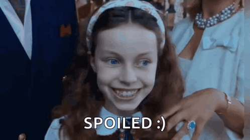 Little Girl Smiling Saying Spoiled Next to Man and Woman