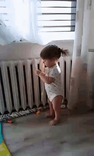 Little Girl Standing in Front of Radiator