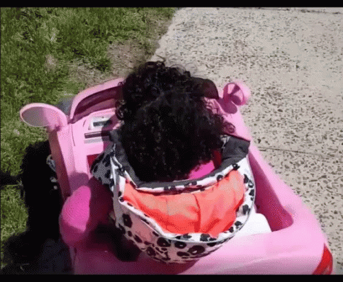 Little Girl With Curly Hair in Pink Car
