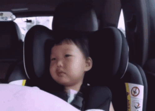 Little Girl With Yellow J in Car Seat