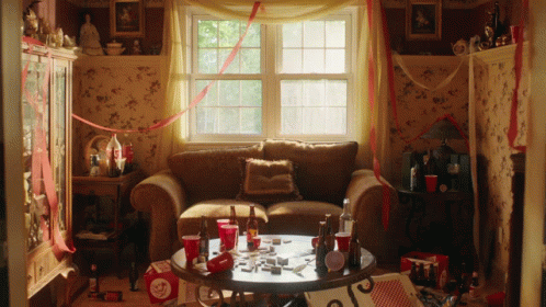 Living Room With Couch and Table Full of Bottles and Cups