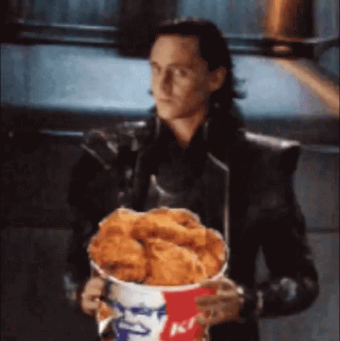 Loki Is Holding A Bucket Of Fried Chicken In His Hands . GIF