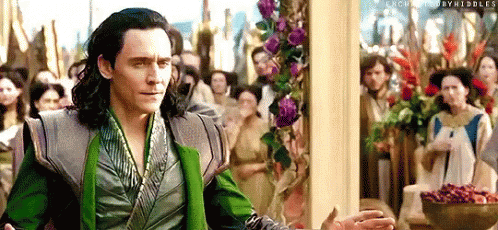Loki Is Standing In Front Of A Crowd Of People In A Room . GIF