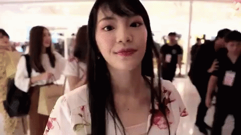Long Black-Haired Woman Looking at Camera in Mall
