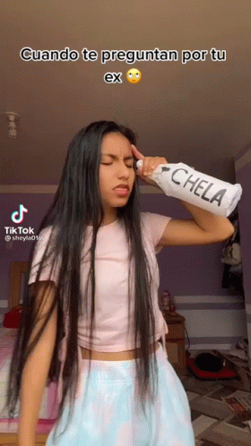 Long Haired Girl Holding Chela Bottle Over Head