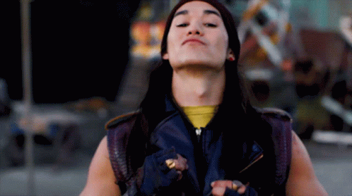 Long-Haired Man in Purple Vest and Yellow Shirt