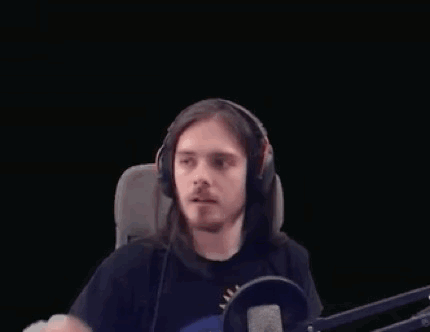 Long-Haired Man With Headphones Making Heart at Microphone