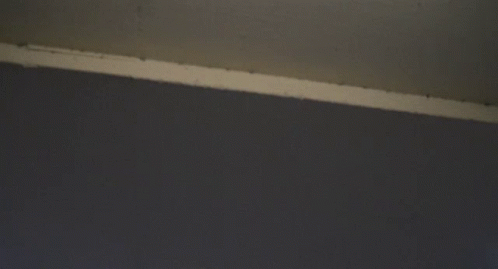 Looking Up At A Very Tall Building With A Cloudy Sky In The Background GIF