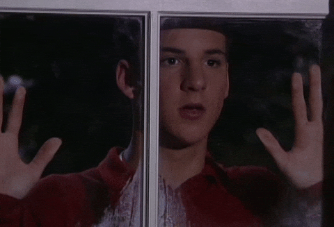 Love Struck Guy Stalking Behind Glass GIF