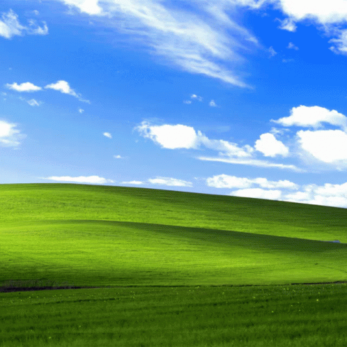 Lush Green Hillside With Blue Sky and White Clouds