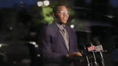 Malachi Love-Robinson in Suit at Microphones