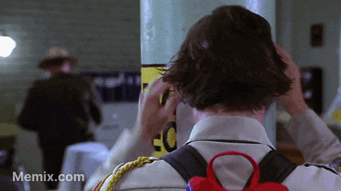 Man Adjusts Hair Near EC Sign