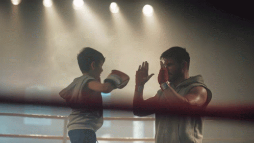 Man and Boy Boxing in Ring