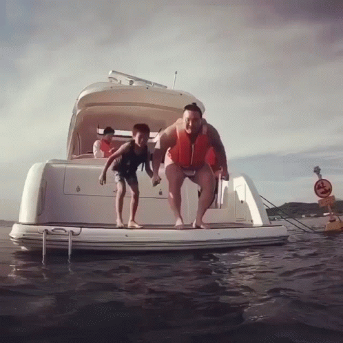 Man And Boy Jumping Off Boat Into Water GIF