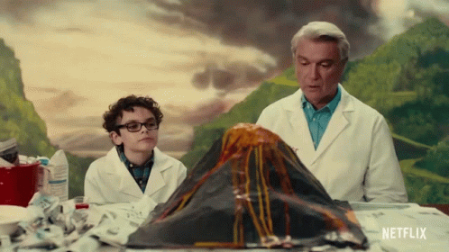Man and Boy Looking at Volcano Model with Netflix Logo