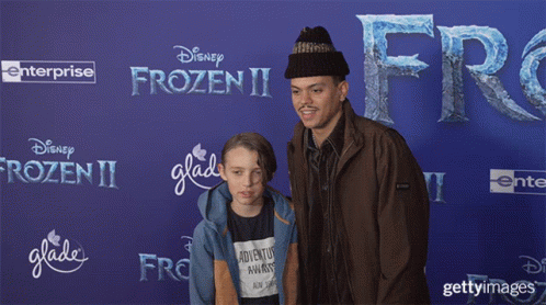 Man and Boy Posing in Front of Disney Frozen II Poster