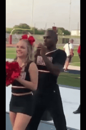 Man And Cheerleader Dancing On Football Field GIF