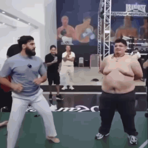 Man and Fat Man Dancing in Boxing Ring Saying Brand Risk