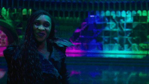 Man and Two Women Dancing Under Purple Lights