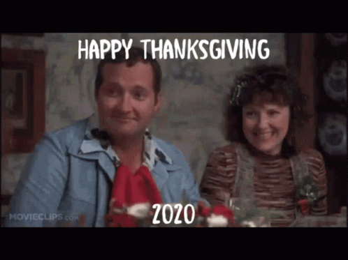 Man and Woman at Table with Happy Thanksgiving 2020 Sign