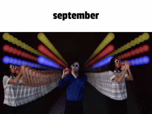 Man and Woman Blowing Bubbles in Front of September Sign